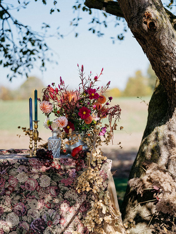Decorative table setting with flowers and candles outdoors