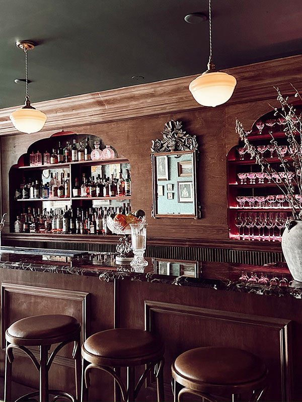 Bar interior with wooden shelves, bar stools, and decorative elements.
