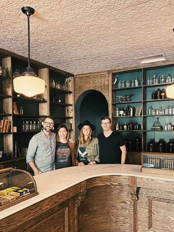 Co-owners standing behind a counter with shelves and decor in the background