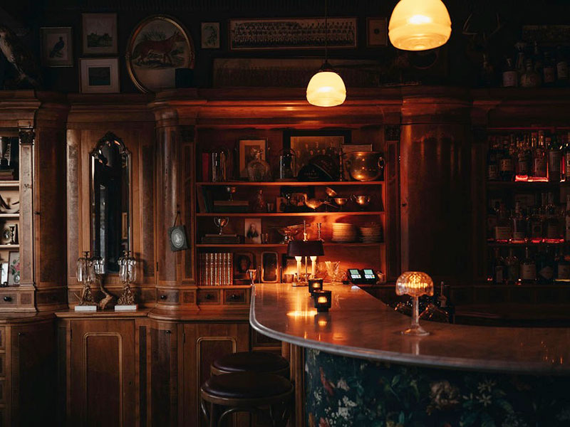 Dark and cozy bar interior with wooden decor and vintage lighting.