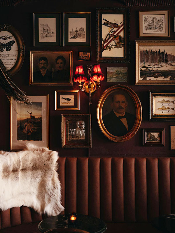 Wall with framed pictures and a lamp at Russ and Co.