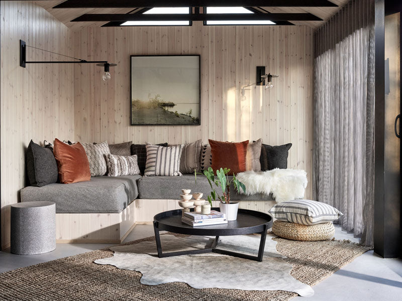 Modern living room with a sectional sofa, coffee table and art by Christine Flynn.