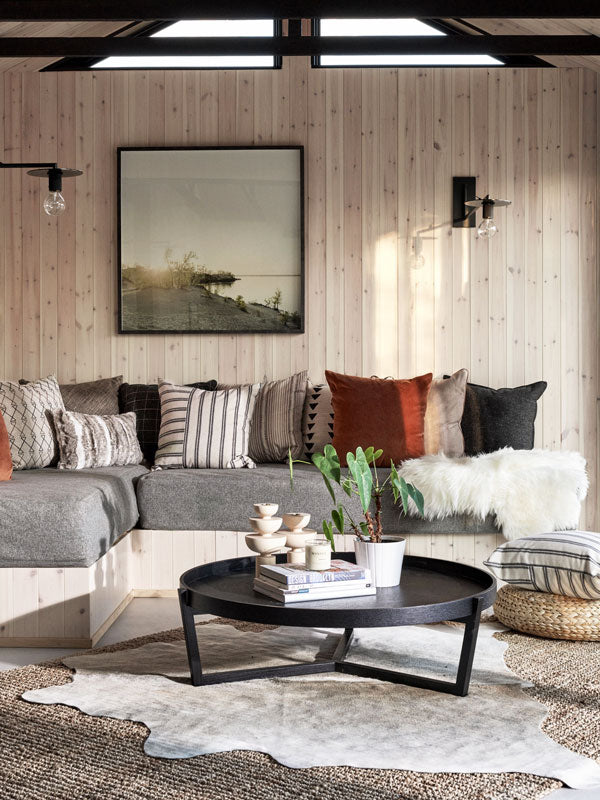 Modern living room with a sectional sofa, round coffee table, and art by Christine Flynn.